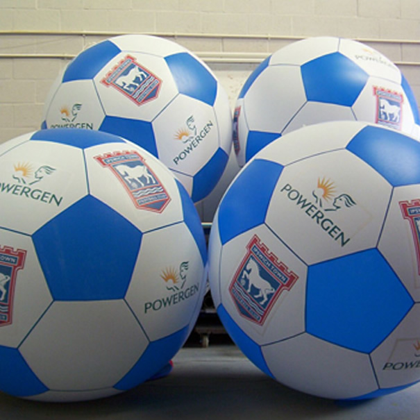 giant blue and white inflatable footballs with Powergen and Ipswich Town branding inside a warehouse