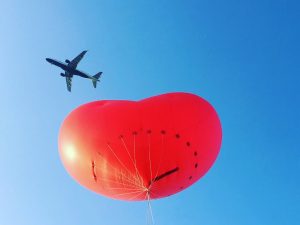 aeroplane flies above chubby heart inflatable
